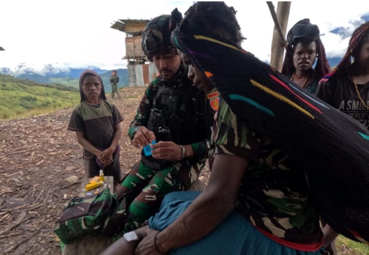 Prajurit Satgas Yonif Para Raider 433/JS saat mengobati kaki seorang mama yang terluka di Distrik Yigi, Kabupaten Nduga, Provinsi Papua Pegunungan (Foto:Istimewa)