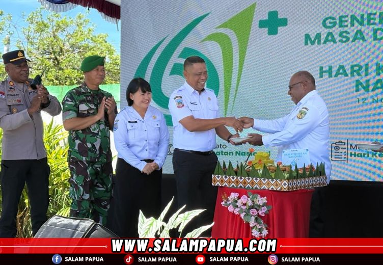 Pemberian tumpeng oleh Wakil Bupati Mimika Emanuel Kemong kepada Kadinkes Mimika Reynold Ubra (salampapua.com/Evita)