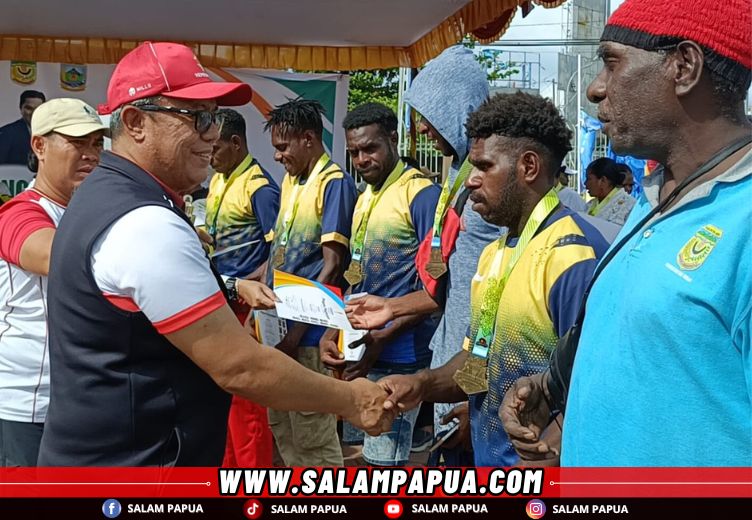 Ketua Tim Tarkam Wilayah Timur Kemenpora RI, Dr. Ruslan saat menyerahkan hadiah kepada juara voli putra (salampapua.com/Acik)